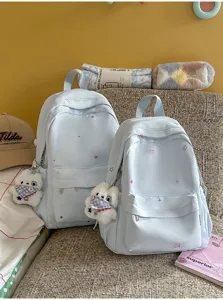 Sac à dos en toile bleu clair avec broderie d'étoiles et pendentif d'ours pour femmes.