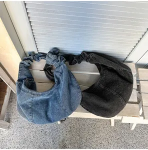 Close up of denim slouchy hobo shoulder bags in blue and dark grey, casual commuter style.