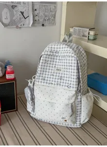 Sac à dos à carreaux gris et blanc pour étudiant, cartable scolaire style décontracté chic.