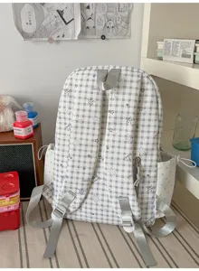 Vue détaillée d'un sac à dos d'école à carreaux décontracté avec des étoiles et bretelles réglables.