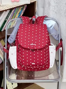 Vue detaillee du sac a dos rouge en nylon avec motif etoiles, cordon de serrage et poches laterales.