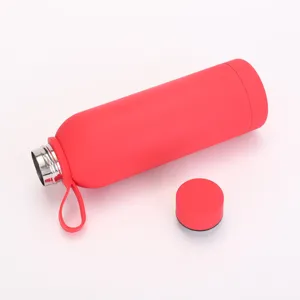 Détail de la bouteille isotherme en acier inoxydable avec poignée et bouchon rouges.