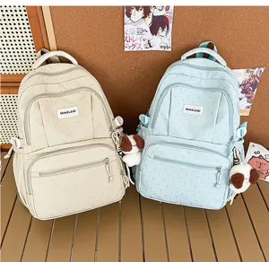 Vue détaillée du sac à dos étudiant à pois avec pendentif chien en peluche et poches pratiques.