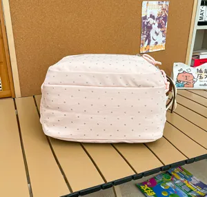 Détail du sac à dos rose à pois, présentant un style collégien mignon et un tissu doux.
