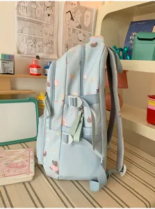 Seitenansicht des hellblauen College Rucksacks mit niedlichem Hundeprint und Seitengurten.