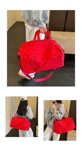 Detailed view of the large red travel duffel bag with white bow pattern, carried by model.