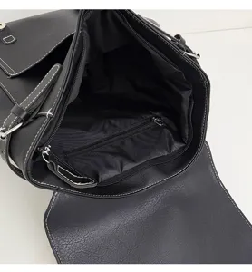 Innendetails des schwarzen PU-Leder-Rucksacks mit geräumigem Hauptfach und Reißverschlusstasche.