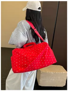 Large capacity red polka dot travel duffel bag showing back wear style detail for short trips.