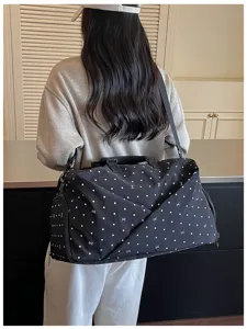 Detail view of the black travel duffel bag with white dots showing the spacious capacity.