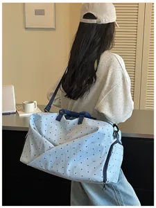 Detail view of a large capacity travel duffel bag with cute dot print and shoulder strap.