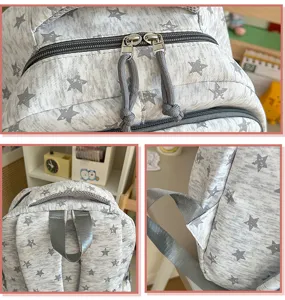 Vue détaillée du sac à dos montrant des fermetures éclair douces et un tissu gris à étoiles.