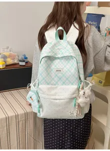 Vue arrière d’un sac à dos vert menthe à carreaux et pois blancs, avec pochettes et breloque peluche