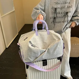 Large capacity travel duffel bag with cute polka dot and bow pattern for short trips.