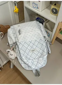 Sac à dos bleu clair à carreaux et pois, avec bretelles grises et petits pendentifs en peluche