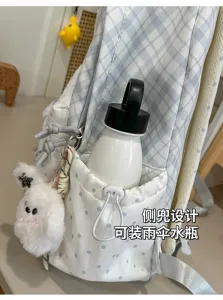 Gros plan sur la poche latérale à cordon avec bouteille, pois et pendentif lapin en peluche