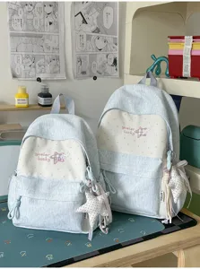 Sac à dos bleu et blanc avec broderie d'étoile mignonne et pendentif en peluche pour l'école.