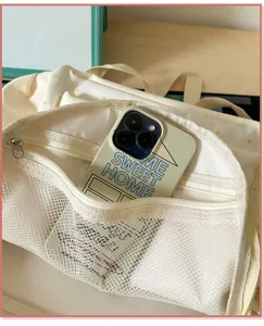 Vue détaillée du sac à dos d'école en toile avec poche en filet avant et grand rangement.