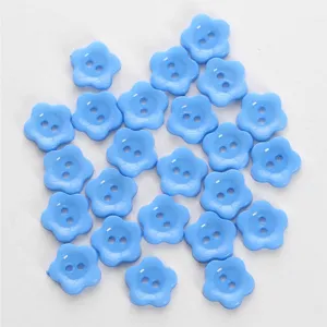 Light blue flower shaped two hole buttons detail shot, cute accessory for garments and crafts.