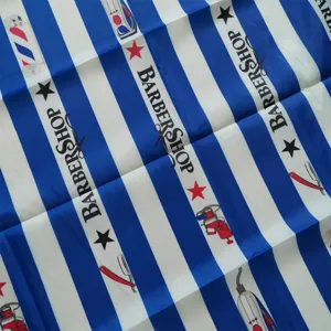 Detailed view of professional salon barber cape featuring classic blue and white stripe print.