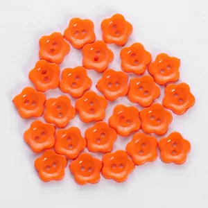 Colorful orange flower shaped two hole buttons for sewing garments crafts and DIY accessories.