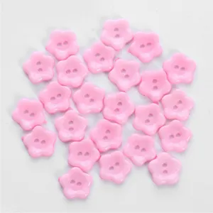 Close-up detail of cute pink flower-shaped two-hole buttons for crafting and DIY sewing accessories.
