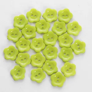 Closeup detail of light green flower shaped two hole buttons, perfect for craft accessories.