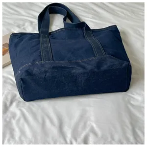 Détail de sac cabas en denim bleu foncé avec tissu résistant et bretelles solides et pratique.