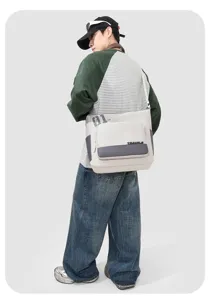 Detail view of the casual canvas messenger bag with contrast flap pocket and shoulder strap.