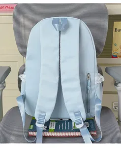 Vista detallada de una mochila azul claro con ribetes de encaje colocada en una silla.