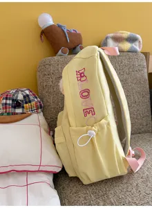 Detailed view of yellow canvas backpack with cute embroidery. Cozy lifestyle scene setup.