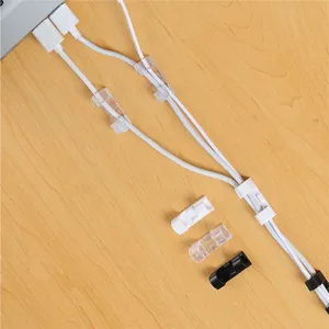 Close-up detail showing transparent and black adhesive cable clips organizing desk wires neatly.