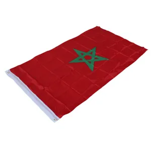 Close-up detail of Morocco flag featuring red cloth and green star with metal grommets.