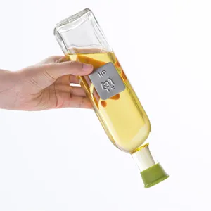 Quadratische Glas-Ölflasche mit grünem Silikondeckel und Metall-Etikett für Küche