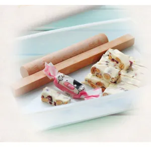 Ensemble d'outils pour plateau de nougat en plastique avec rouleau en bois et bonbons.