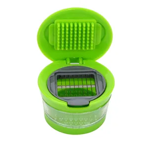 Multifunctional manual garlic chopper with stainless steel blades and cleaning tool for kitchen use.