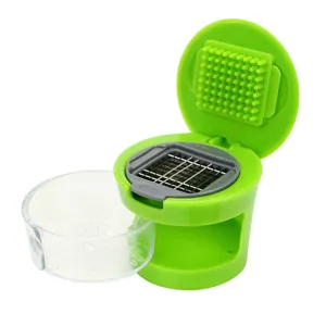 Close-up of garlic chopper with sharp stainless steel blade grid and clear container.