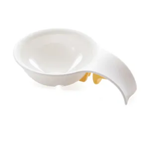 Detailed view of a white egg white separator featuring a practical yellow bowl edge clip.