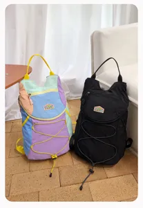 Vista detallada de mochilas colorblock dopamina y negras para viajes y deportes al aire libre.