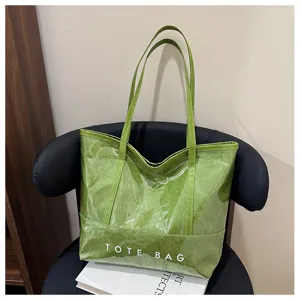 Detailansicht einer grünen glänzenden wasserdichten Tasche, Textur und Henkel sichtbar.