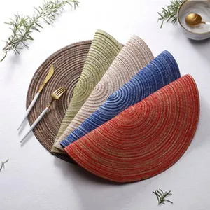 Vue détaillée de set de table rond en PVC tissé multicolore joliment disposé sur la table.
