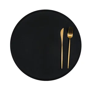 Round black leather placemat with gold cutlery for modern dining table and restaurant decor