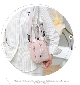 Detail shot of a pink canvas crossbody phone bag featuring a convenient drawstring closure.
