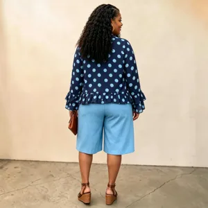 Detail view of plus-size polka dot long-sleeve blouse with ruffle hem and matching shorts.
