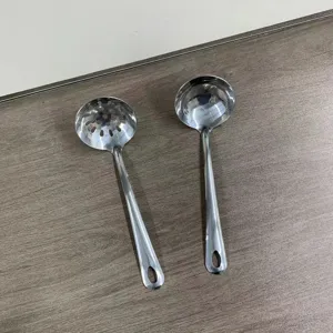 Edelstahl Küchenutensilien Detailansicht mit Schaumlöffel und Suppenkelle Werkzeug.