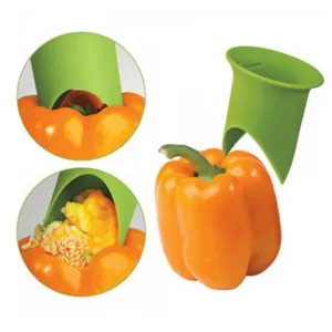 Detailed view of green pepper corer tool showing easy seed removal operation on fresh bell pepper.