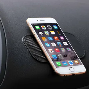 Detailed view of a black silicone car anti-slip phone mat placed securely on dashboard.