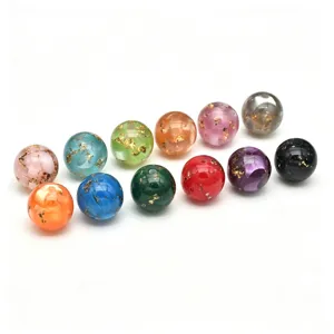 Gros plan de perles en résine colorées avec des paillettes d'or, idéales pour le bricolage DIY.