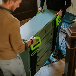 Dettaglio di cinghie di sollevamento resistenti con maniglie verdi ergonomiche in uso.