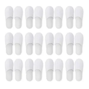 Detailed view of white closed-toe disposable hotel slippers arranged neatly in a grid.