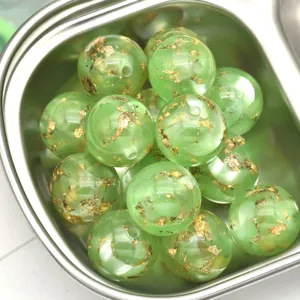 Vue détaillée de perles en résine verte nacrée de 16mm avec feuille d'or pour bricolage.